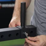 A close-up of the loadable Olympic-sized weight plate sleeve on the Lower Body Machines H-PND, with plates loaded