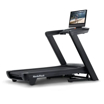 A person running at high speed on the NordicTrack Commercial 2450 Treadmill, with the large 24-inch touchscreen visible