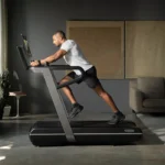 Athlete performing a weighted sled push simulation on the Technogym Run HIIT Treadmill
